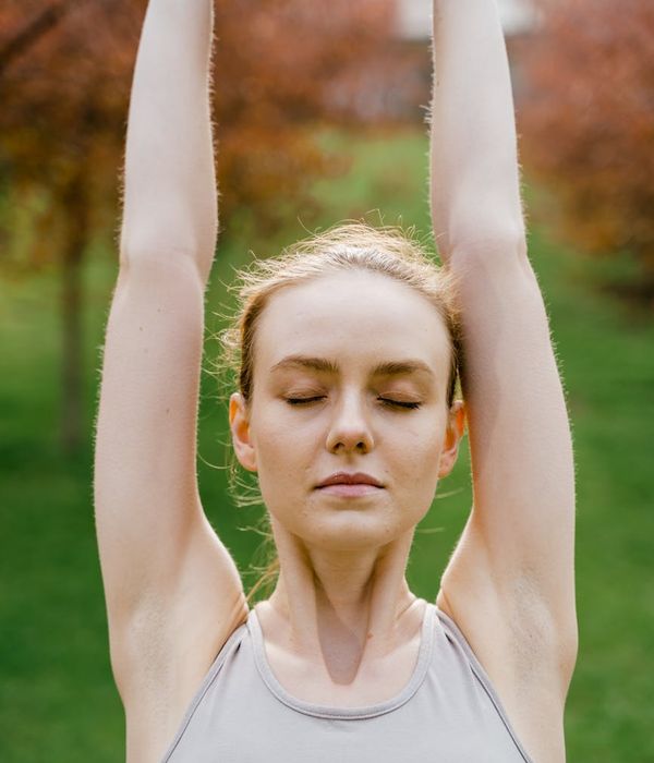 Woman practicing a calming breathing exercise outdoors.
